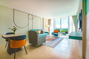 uma sala de estar com um sofá, cadeiras e uma mesa em Hilltop Wellness Resort em Phuket