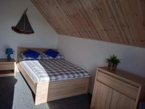 a bedroom with a bed with blue pillows at Nadmorski Zakątek in Jastrzębia Góra