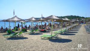 a beach with chairs and umbrellas and people on it at Perfect Apartment in Nea Potidaea