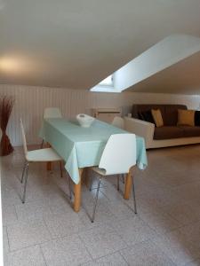 einen Tisch und Stühle im Wohnzimmer mit Sofa in der Unterkunft Casa vicino al mare in Rimini