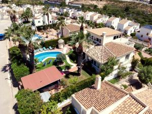 een luchtzicht op een huis met een zwembad en palmbomen bij Holiday VILLA GOLF & SEE VIEW Villamartin in Orihuela-Costa