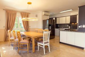 a kitchen and dining room with a wooden table and chairs at Holiday VILLA GOLF & SEE VIEW Villamartin in Orihuela Costa