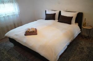 uma grande cama branca com duas toalhas em apartman Vidović em Livno