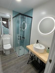 een badkamer met een wastafel en een glazen douche bij Casa Rural La Peña in Tarifa