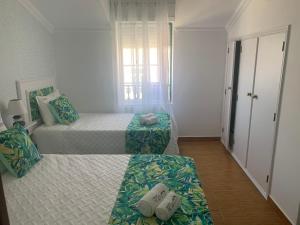 um quarto com 2 camas e uma janela em Moradia Ricardo - Nazaré em Nazaré