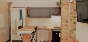 uma cozinha com uma mesa e uma parede de tijolos em Maximilian Seven em Aiello del Friuli