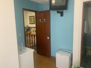 um quarto com uma porta e uma televisão num quarto em Moradia Ricardo - Nazaré em Nazaré
