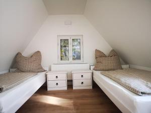 2 Betten in einem Zimmer mit Fenster in der Unterkunft Ferienhaus Elbsicht in Pirna