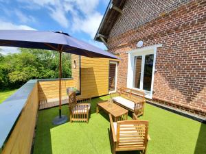 een patio met een tafel en stoelen en een parasol bij La Suite du Hameau in Sierville