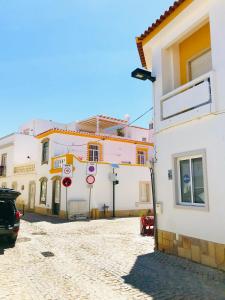 eine Gruppe von Gebäuden auf einer Kopfsteinpflasterstraße in der Unterkunft Casa Do Gilao in Tavira