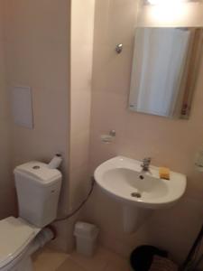 a bathroom with a white toilet and a sink at Apartment Comfort in Sunny Beach