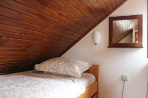 Cama en habitación con techo de madera en Hiška Čatež, en Brežice