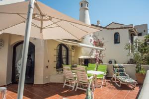 eine Terrasse mit einem Tisch, Stühlen und einem Sonnenschirm in der Unterkunft Luxuriöse und großräumige Villa mit Community Pool, Sicht auf das Mittelmeer sowie dem Mar Menor, La Manga Club in Atamaría