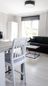 einen weißen Stuhl neben einem Tisch im Wohnzimmer in der Unterkunft Centrum Apartement in Valga