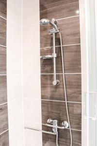 a shower in a bathroom with white tiles at Centrum Apartement in Valga