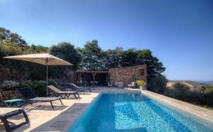 a swimming pool with chairs and an umbrella at Au pied des oliviers in Calenzana