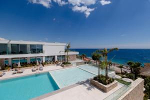 a swimming pool with the ocean in the background at Empire Beach Resort ADULTS ONLY in Dhërmi