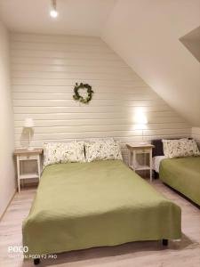 クドヴァ・ズドゥルイにあるApartamenty u Kasiのベッドルーム1室(緑色のベッド2台、テーブル2台付)