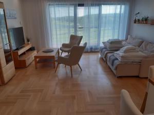 uma sala de estar com um sofá e uma mesa em Apartamenty przy Stoku Mrągowo em Mrągowo