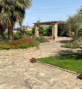 a garden with a stone walkway and a flower pot at Villa Russo in Caltanissetta
