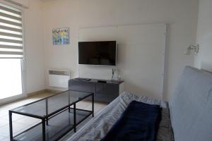 TV a/nebo společenská místnost v ubytování L'Océanide - Appartement avec balcon-terrasse et parking privé