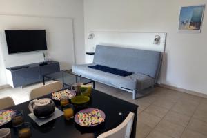 a living room with a bed and a table with food at L'Océanide - Appartement avec balcon-terrasse et parking privé in Pont-lʼAbbé