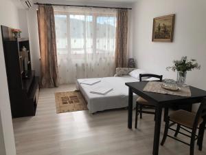 sypialnia z łóżkiem, stołem i oknem w obiekcie Pensiunea Cazanele Dunarii w mieście Dubova