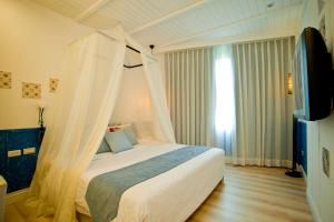 1 dormitorio con 1 cama con dosel en Ho Huan B & B, en Kenting