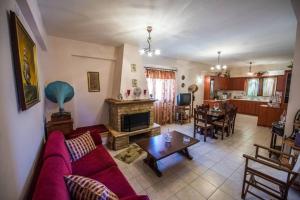 un soggiorno con un divano rosso e un camino di Kelly's Villa in Stoupa a Neokhórion