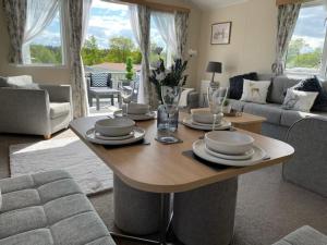 a living room with a table with dishes on it at Hot Tub 9 The Fairways in Alnwick +19 photos