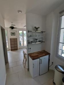 een keuken met witte muren en een tafel en planken bij Mistral Mouans-Sartoux in Mouans-Sartoux