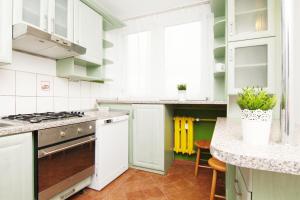 a kitchen with white cabinets and a stove top oven at Blue River - Jelenia in Wrocław
