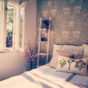 a bedroom with a bed with a floral wallpaper at Villa Vintage B&B in Nauvo