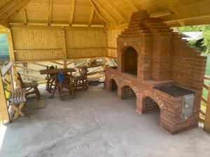 a brick oven in a pavilion with a table at Pensiunea Pisc in Tuştea