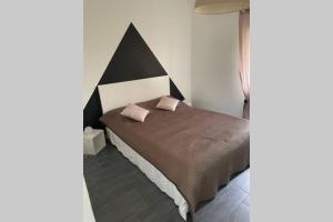 ein Schlafzimmer mit einem Bett mit zwei rosa Kissen darauf in der Unterkunft Maison avec jardin à 8 min de l'aéroport in Saint-Victoret