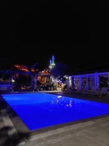 ein Schwimmbad in der Nacht mit einem Gebäude im Hintergrund in der Unterkunft CC's Butik Hotel in Oludeniz