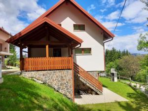 a house in the mountains with a stone wall at Apartma Ribnica na Pohorju in Ribnica na Pohorju