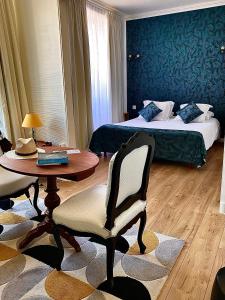 Hôtel Le Plantagenet في شينون: غرفة فندق بها سرير وطاولة وكراسي