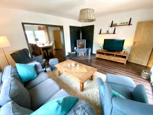 ein Wohnzimmer mit einem Sofa, einem Tisch und einem TV in der Unterkunft Haus im Grünen in Bornheim