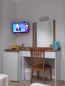 a room with a desk with a tv on the wall at CC's Butik Hotel in Oludeniz