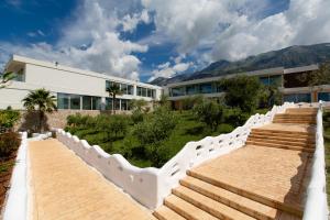 a building with stairs in front of a building at Empire Beach Resort ADULTS ONLY in Dhërmi