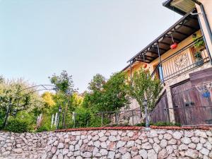 uma casa com uma cerca e uma parede de pedra em Paradise garden em Saraievo
