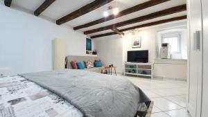 a white bedroom with a bed and a tv at Studio Tony in Dubrovnik