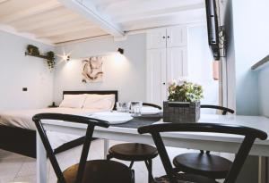 uma sala de jantar com uma mesa e cadeiras e uma cama em La Perla em Parma