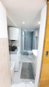 a white bathroom with a toilet and a sink at Studio Tony in Dubrovnik