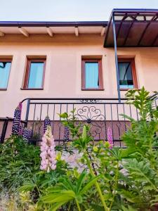 a house with a balcony with flowers in front of it at Paradise garden in Sarajevo