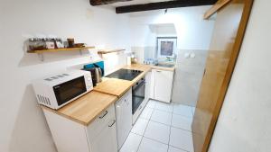 a small kitchen with a microwave and a sink at Studio Tony in Dubrovnik