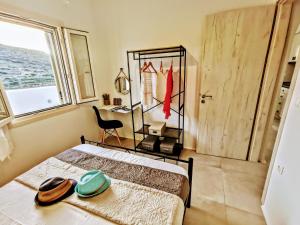 a bedroom with a bed and a desk and a window at Zeidoron Country Houses Naxos (Gaia House) in Káto Potamiá