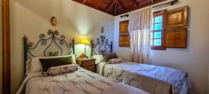 Un dormitorio con dos camas y una lámpara y una ventana. en Finca Villa Arriba, en Arecida