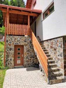 um edifício com uma escada de pedra e uma porta de madeira em Apartma Ribnica na Pohorju em Ribnica na Pohorju